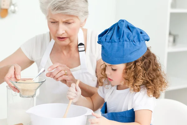 一个小女孩与她的祖母烘烤 — 图库照片
