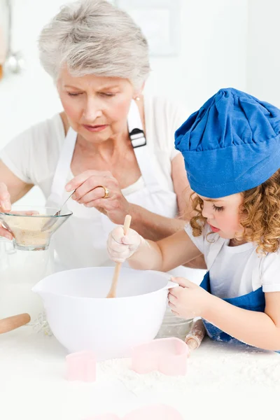 Uma garotinha cozinhando com a avó — Fotografia de Stock