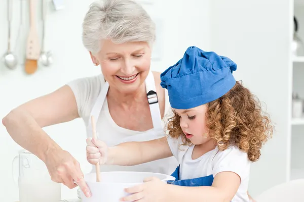 Een klein meisje bakken met haar grootmoeder — Stockfoto