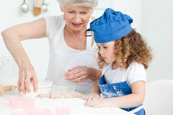 Een klein meisje bakken met haar grootmoeder — Stockfoto