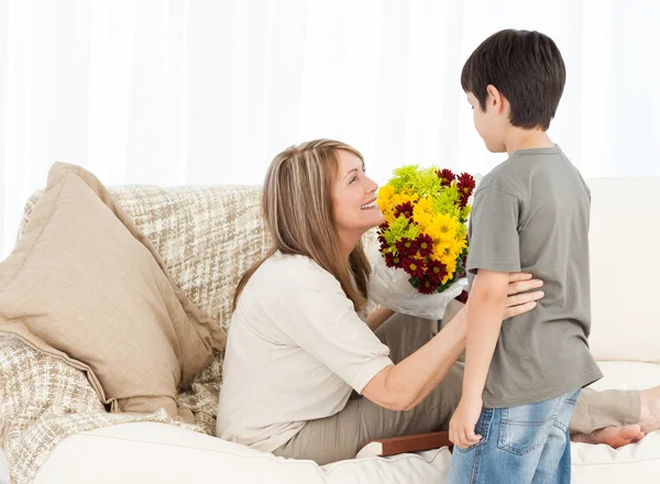 Çocuk büyükannesine çiçek sunan — Stok fotoğraf