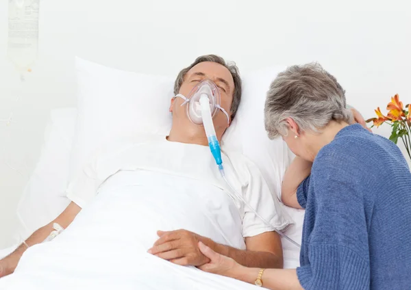 Üzgün emekli kadın kocasıyla bir hastanede — Stok fotoğraf