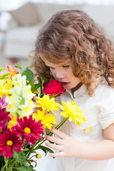 Ein kleines Mädchen, das Blumen riecht — Stockfoto