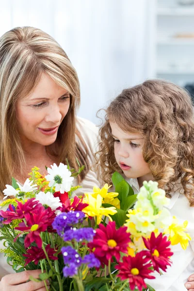 Babcia z małą dziewczynką biorąc kwiaty — Zdjęcie stockowe