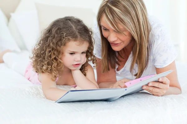 Młoda dziewczyna czytając książkę z babcią — Zdjęcie stockowe