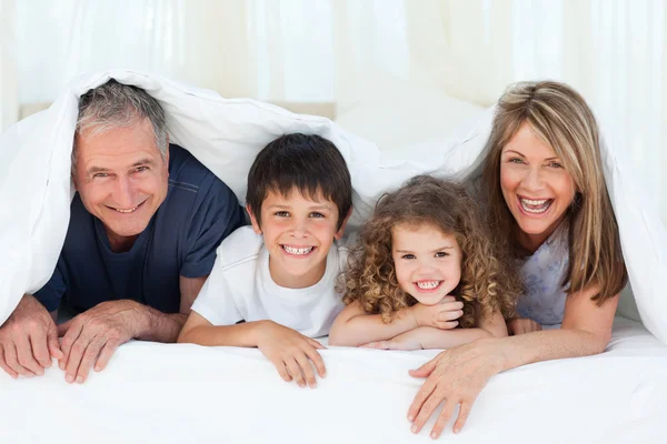 Familie im Schlafzimmer schaut zu Hause in die Kamera — Stockfoto