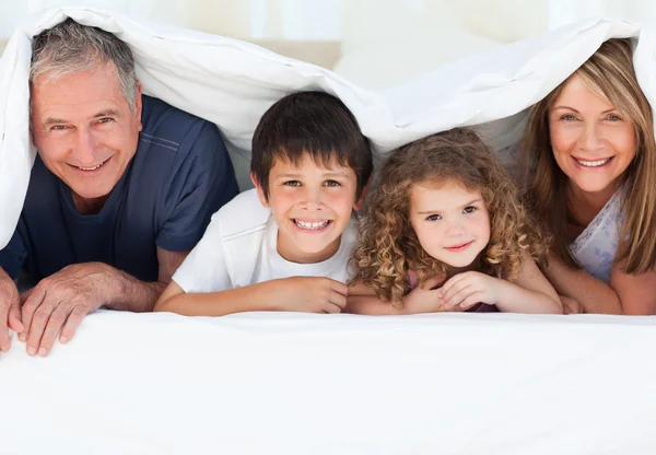 Familie im Schlafzimmer schaut zu Hause in die Kamera — Stockfoto
