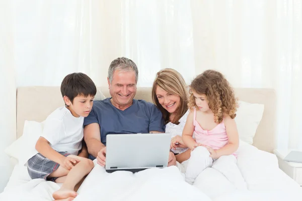 Familie schaut auf ihren Laptop — Stockfoto