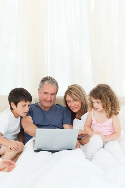 Семья смотрит на свой ноутбук — стоковое фото