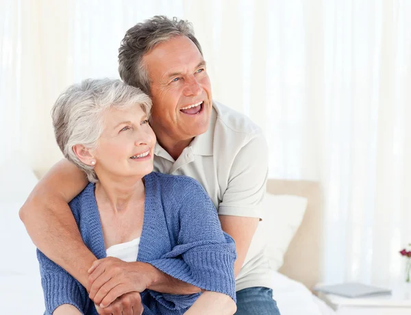 Senior couple hugging on their bed — Stock Photo, Image