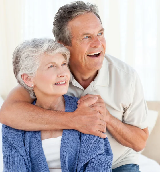 Seniorpaar umarmt sich auf dem Bett — Stockfoto
