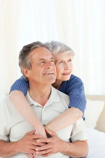 Senior couple hugging on their bed — Stock Photo, Image