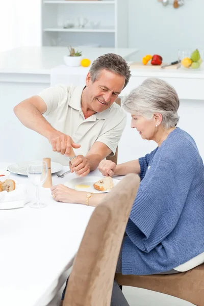 Casal aposentado comendo na cozinha — Fotografia de Stock