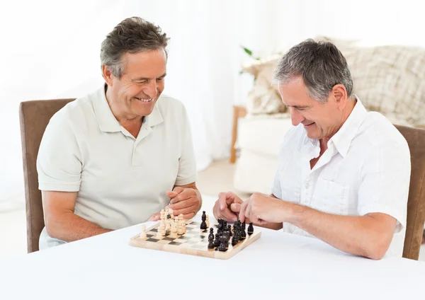 Сеньоры играют в шахматы на столе — стоковое фото