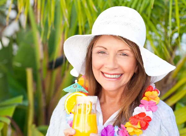 Пенсионерка пьет коктейль под солнцем — стоковое фото