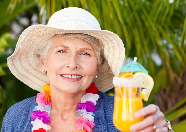 Пенсионерка пьет коктейль под солнцем — стоковое фото