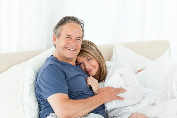 Seniorenpaar legt sich auf sein Bett — Stockfoto