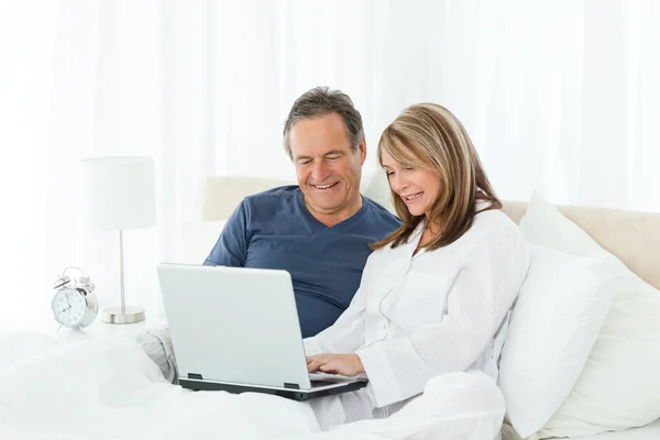 Mature lovers looking at their laptop — Stock Photo, Image