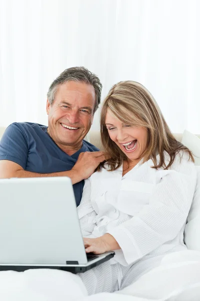 Mature lovers looking at their laptop — Stock Photo, Image