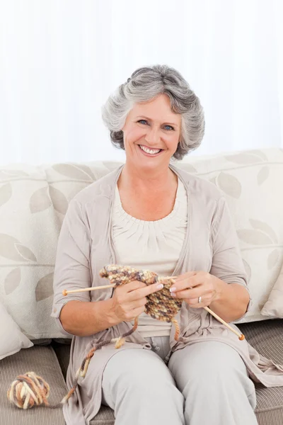 Senior vrouw breien op haar bank — Stockfoto