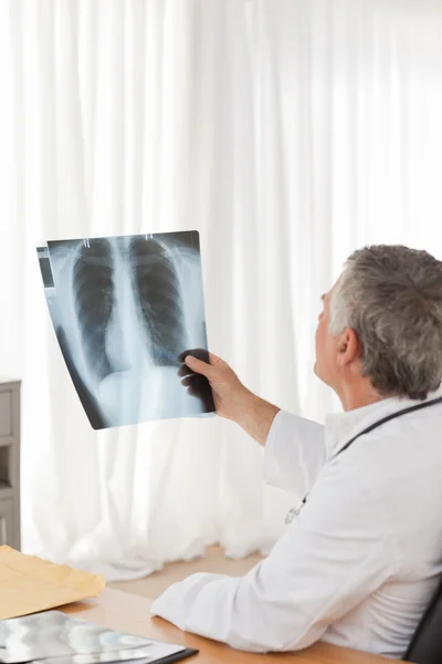 Um médico sénior a olhar para o raio-X — Fotografia de Stock