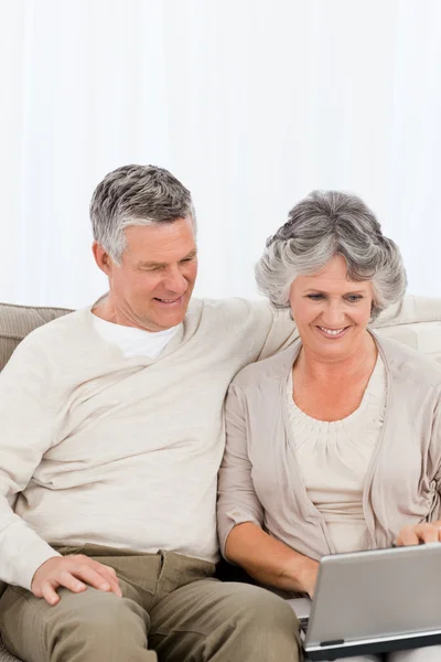 Gli amanti in pensione guardando il loro computer portatile — Foto Stock