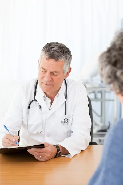 Un médico mayor hablando con su paciente — Foto de Stock