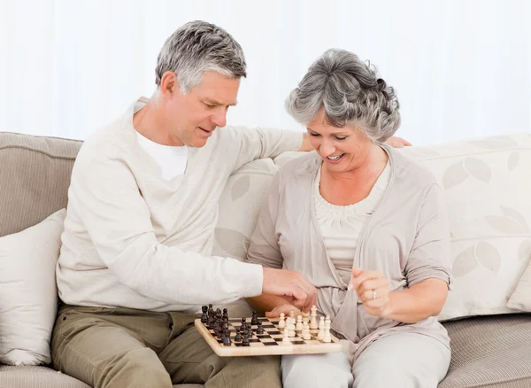 Пара, играющая в шахматы на диване — стоковое фото