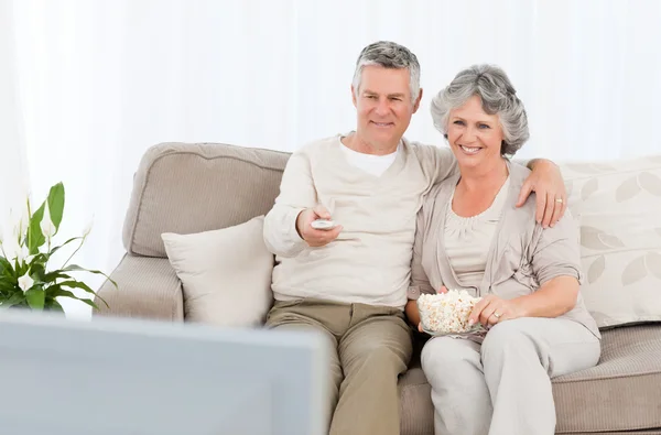 Mature couple watching tv in their living room — Stock Photo, Image