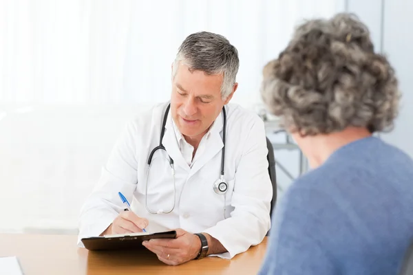 Un médecin chevronné parlant à son patient — Photo