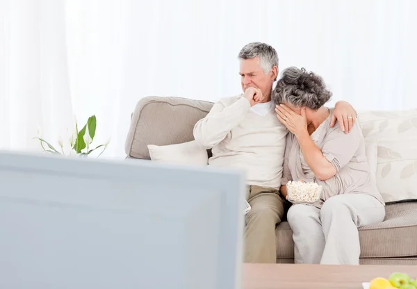 Äldre par tittar på tv i deras vardagsrum — Stockfoto