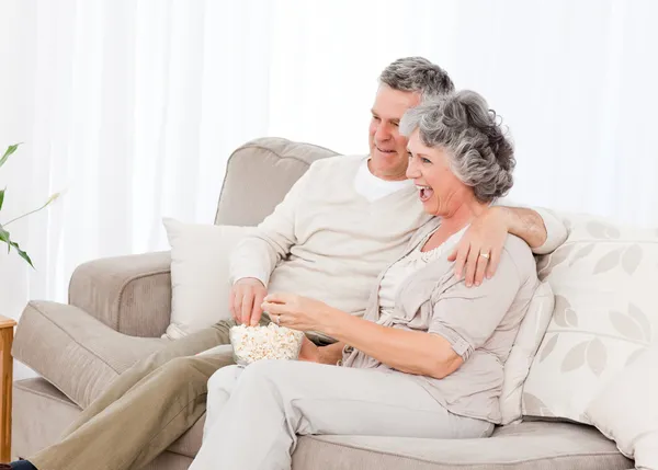 Mature couple watching tv in their living room — Stock Photo, Image