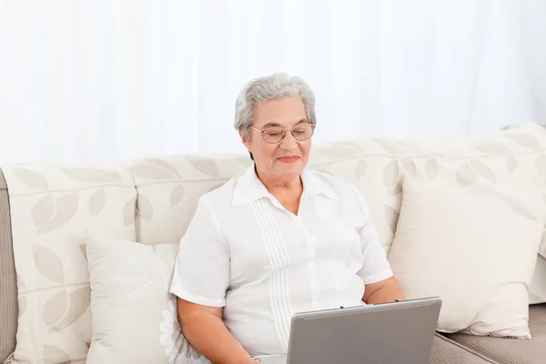 Жінка дивиться на свій ноутбук вдома — стокове фото