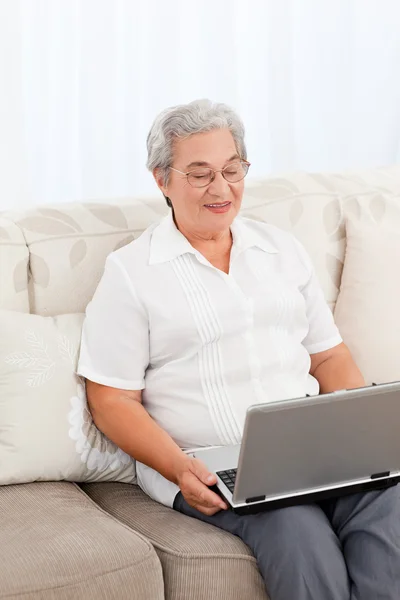 그녀의 휴대용 퍼스널 컴퓨터 집에서 보고 하는 여자 — 스톡 사진