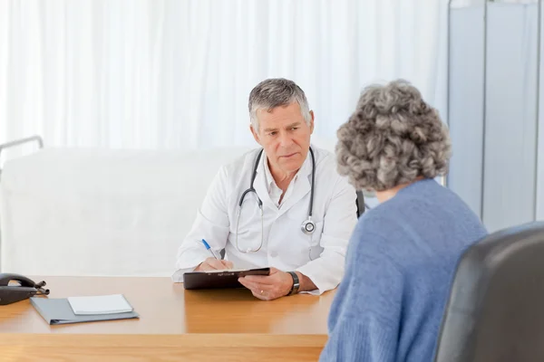 Ein leitender Arzt im Gespräch mit seinem Patienten — Stockfoto