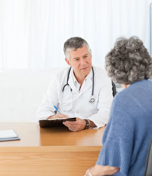 Un médico mayor hablando con su paciente — Foto de Stock