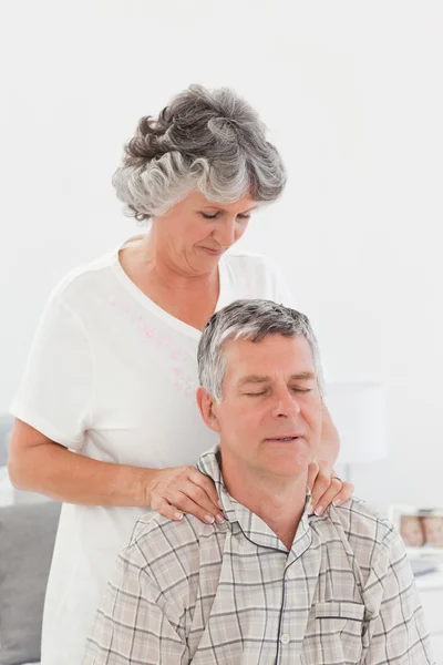 Ушедшая в отставку женщина делает массаж своему мужу дома — стоковое фото