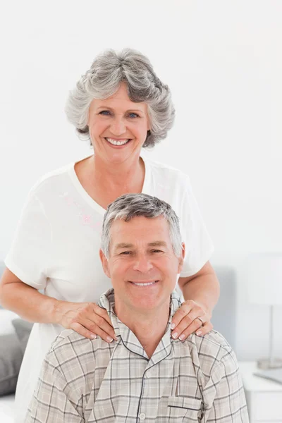 Retired woman giving a massage to her husband at home — Stock Photo, Image