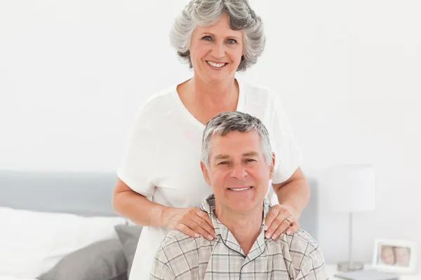 退休的妇女向她的丈夫在家里给做按摩 — 图库照片