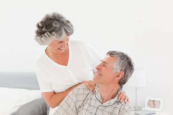 退休的妇女向她的丈夫在家里给做按摩 — 图库照片