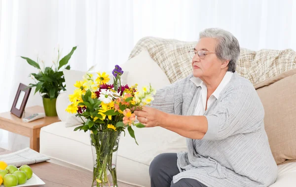 Femme âgée avec des fleurs — Photo