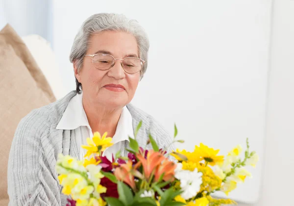 年配の女性の花を持つ — ストック写真