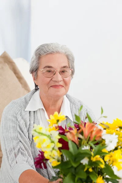 年配の女性の花を持つ — ストック写真
