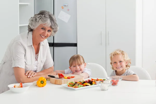 子供たちの家庭で自分たちの祖母と料理 — ストック写真