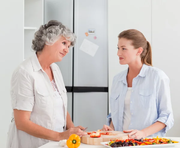 Vrouw met haar moeder thuis koken — Stockfoto