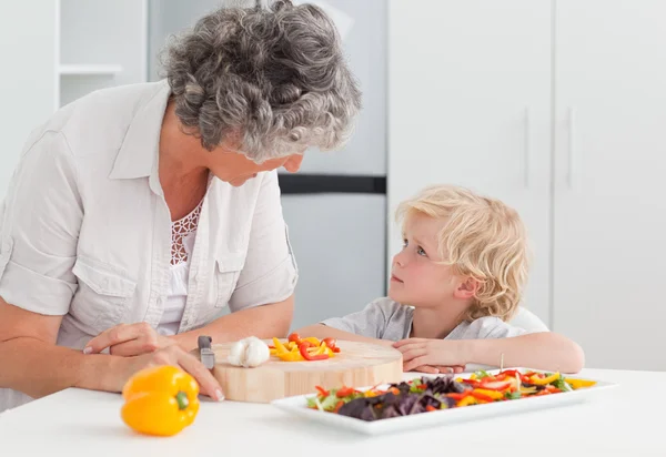 Liten pojke tittar på hans mormor matlagning hemma — Stockfoto