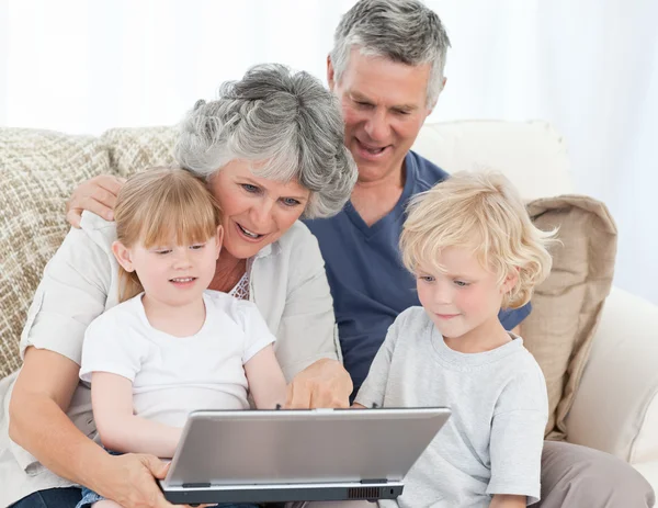 Adorable family looking at the laptop — Stock Photo, Image