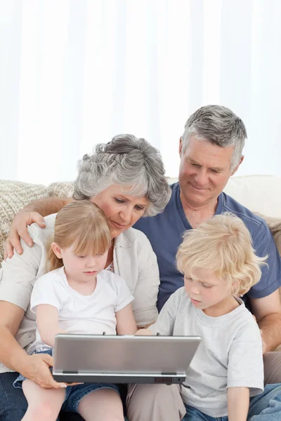 Bedårande familj titta på den bärbara datorn — Stockfoto