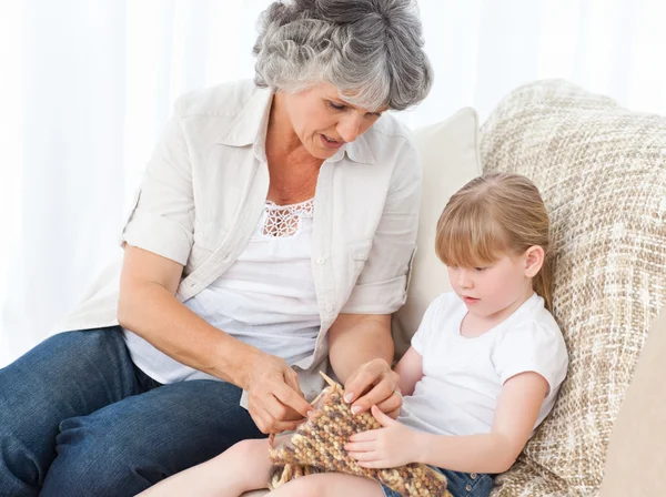 Babcia pomaga jej dziewczynki na drutach — Zdjęcie stockowe