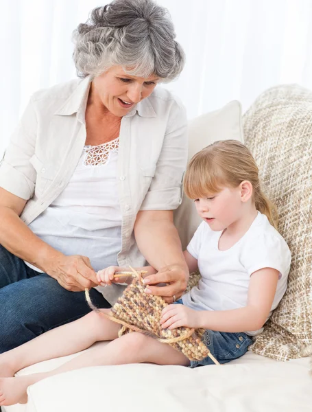 Nonna aiutare la sua bambina a maglia — Foto Stock